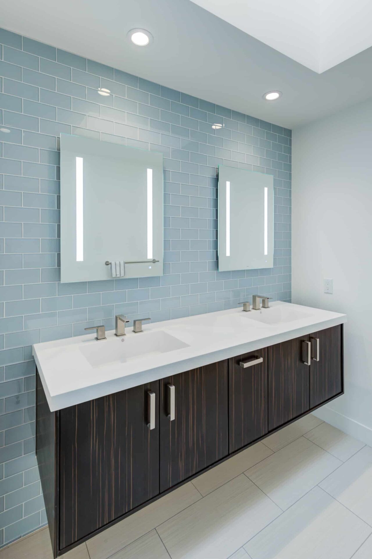 Modern bathroom vanity and blue subway tile.