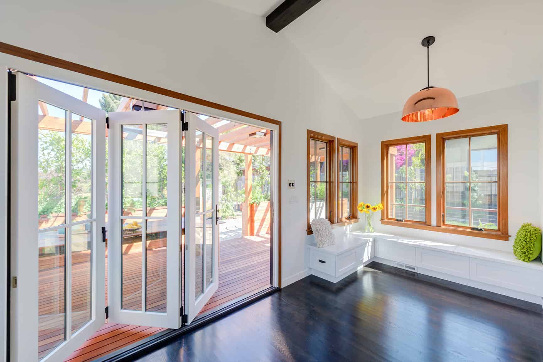 Interior view of sunroom addition with glass accordion doors to the exterior.