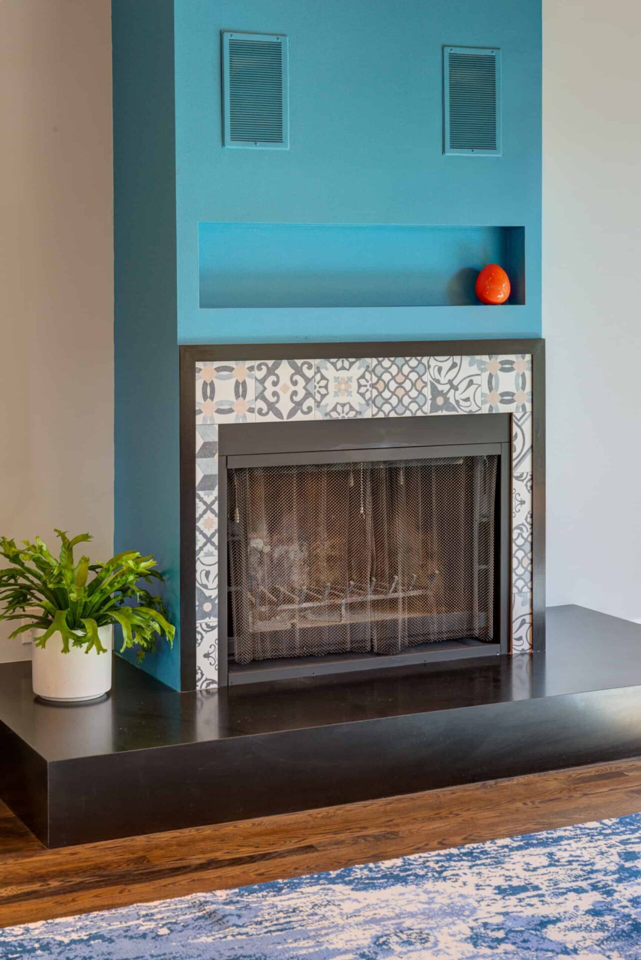 Unique fireplace with striking blue paint and tiles.