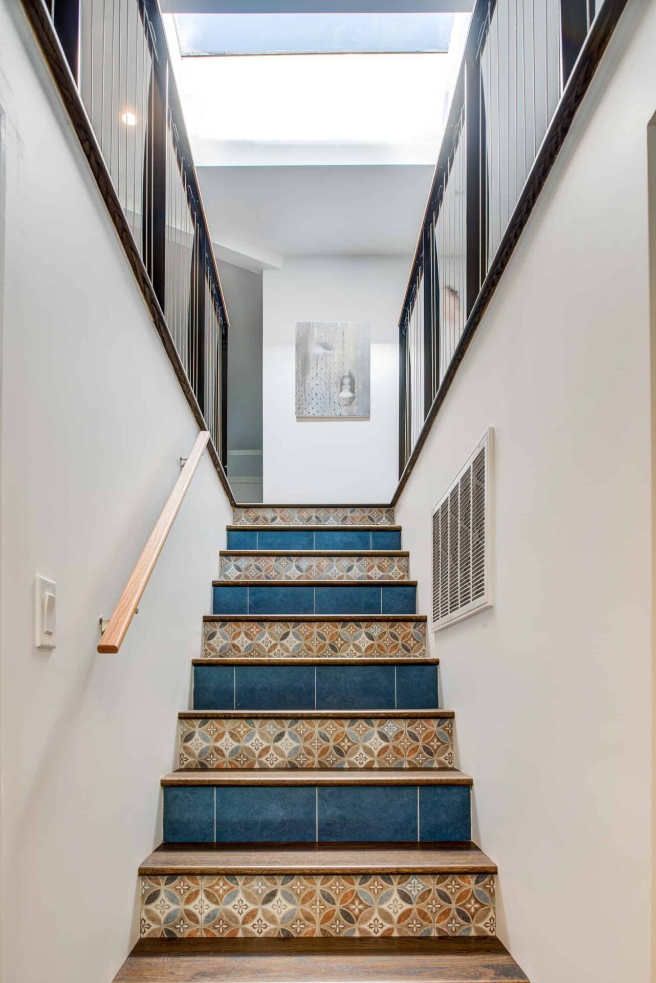 View of home staircase with unique tiling.