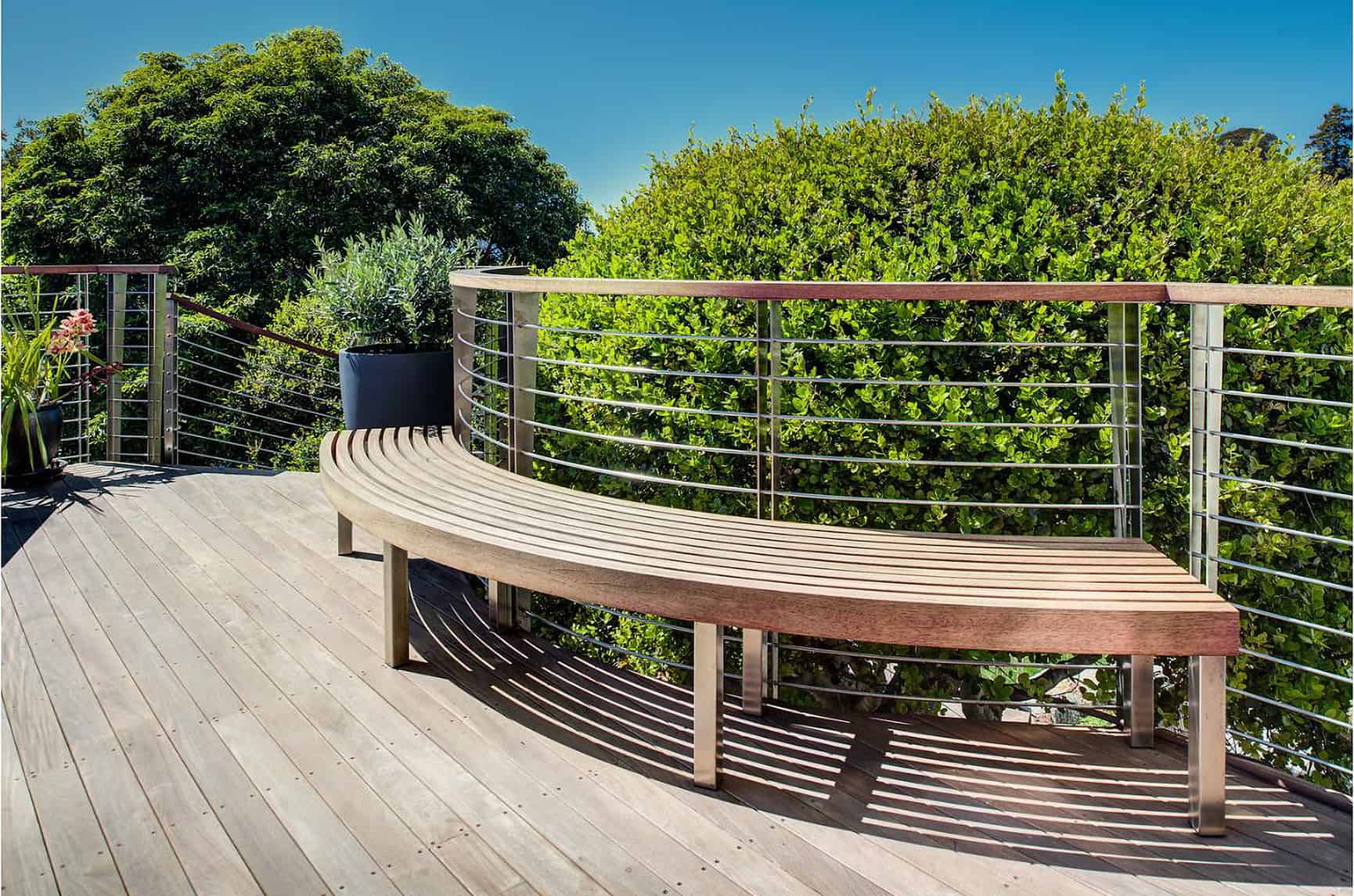 Curved bench and metal railing on elevated deck.
