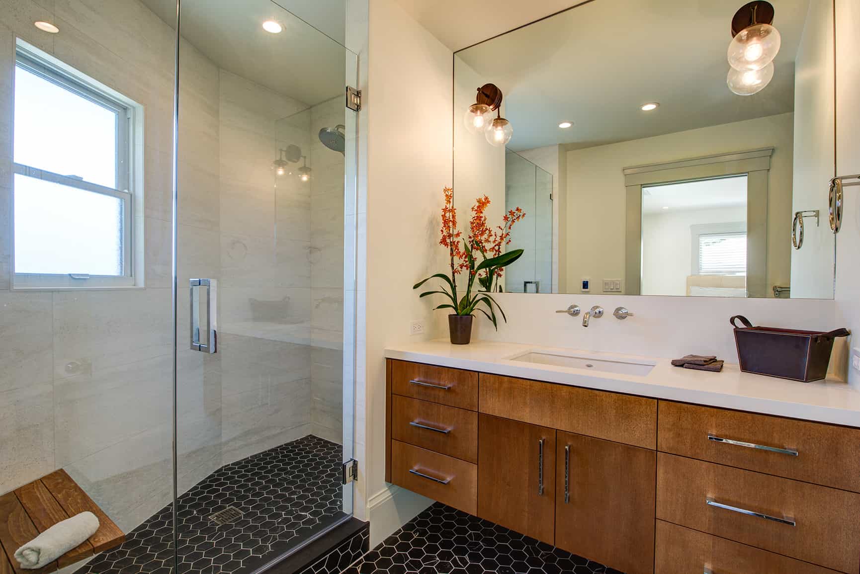 Interior of modern bathroom with vanity and shower.