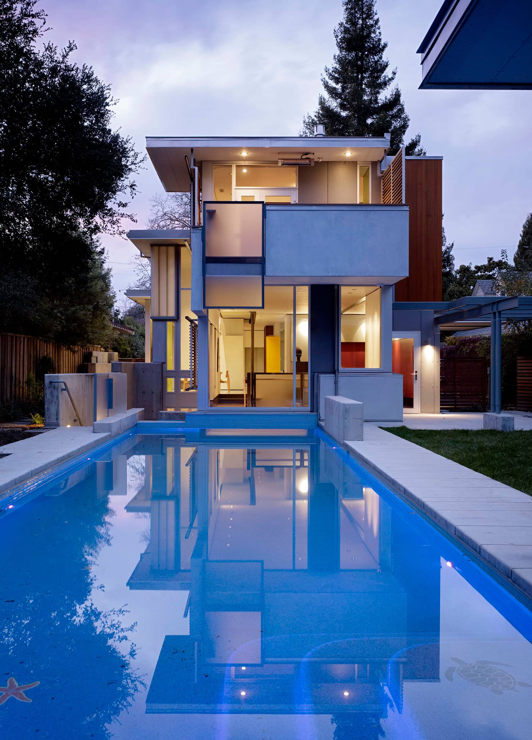 Bright blue pool attached to mid-century modern home.