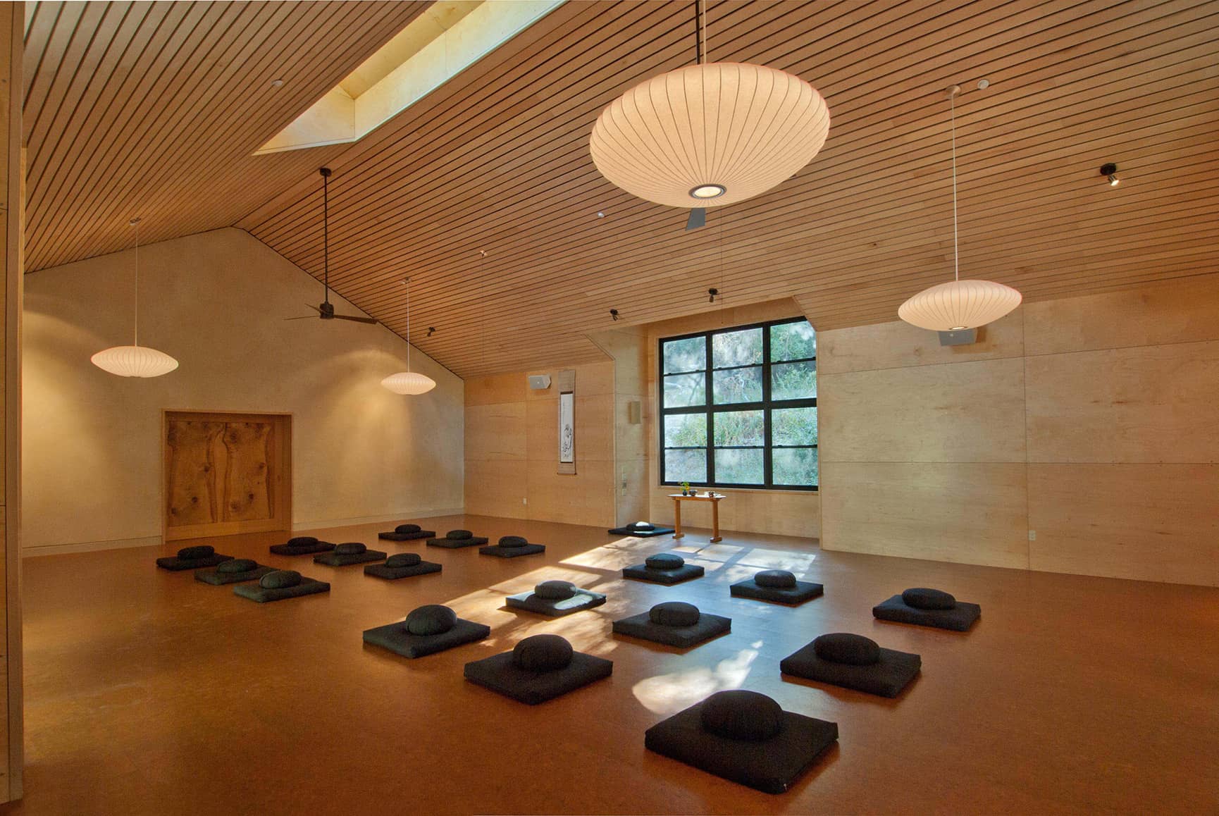 Interior view of newly constructed building used as a yoga retreat with light streaming in.