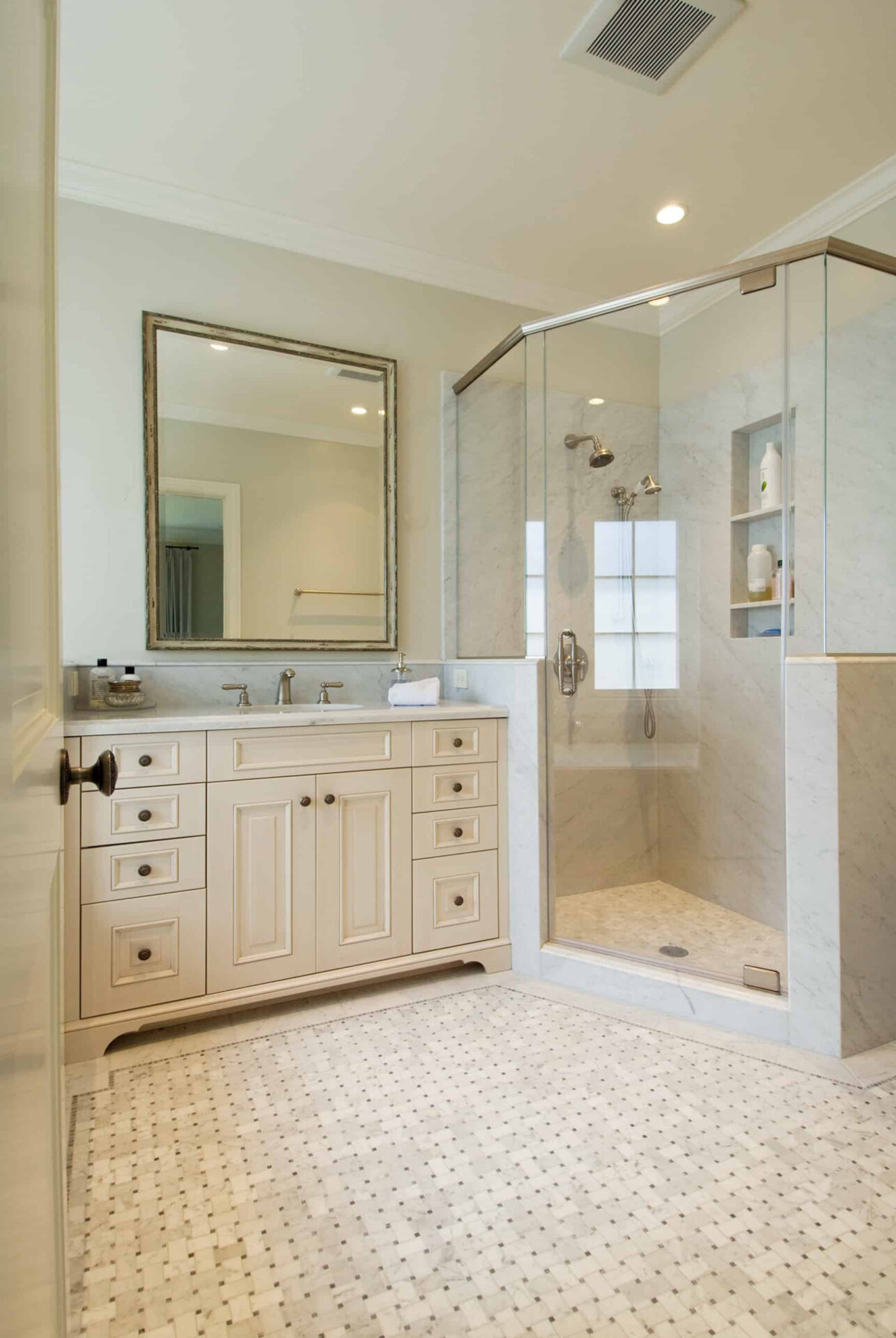 Beautiful neutral color bathroom with tiled floor and glass enclosed shower.