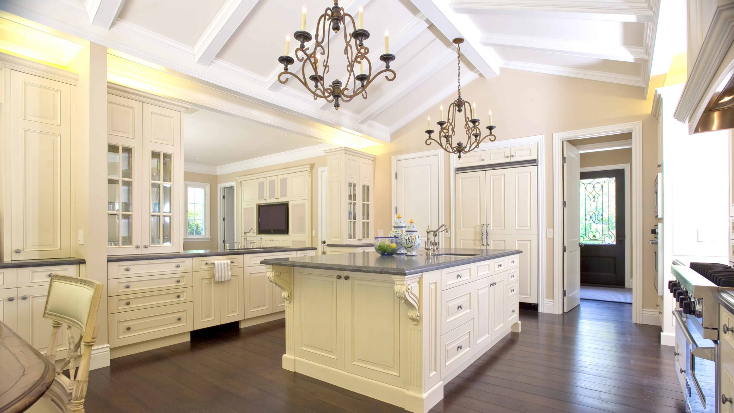 Ornate kitchen with large island and dark wood floors.