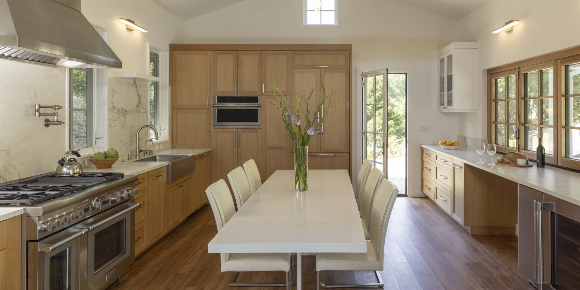 Gorgeous Pool House ADU kitchen with pass through wet bar and panel fridge with chef's range.